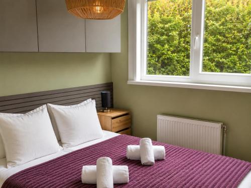 a bedroom with a bed with towels on it at Steam & Dream - Hottub & Sauna Retreat - Free WiFi - Full Privacy - Luxury Experience in Heinkensand