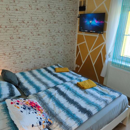 a bed in a room with a tv on a wall at Ferienwohnung Einsiedler - für 4 Personen mit Terrasse und Grill in Windisch Minihof