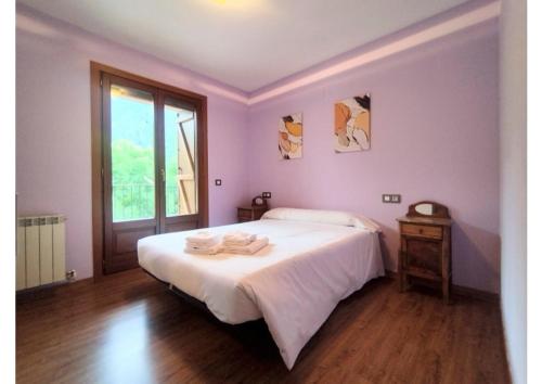 a bedroom with a large white bed and a window at Check-in casas Mesón Casa Cereza in El Run