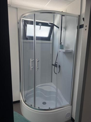 a shower stall with a glass door in a room at Ubytování pod Třešní in Telč
