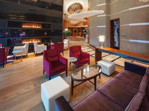 eine Lobby mit Stühlen, einem Tisch und einer Bar in der Unterkunft Movenpick Hotel Ankara in Ankara