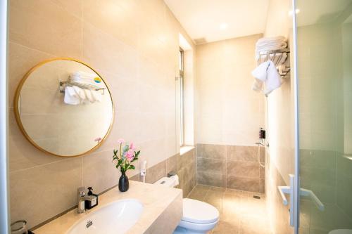 ein Badezimmer mit Waschbecken, Toilette und Spiegel in der Unterkunft May The Hotel in Cần Thơ