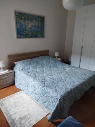a bedroom with a bed with a blue comforter at Casa Lilly in Omegna