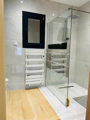 a bathroom with a shower and a television in it at L'évasion in Corent