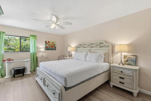 a bedroom with a white bed and a ceiling fan at Sea Woods 115 in New Smyrna Beach