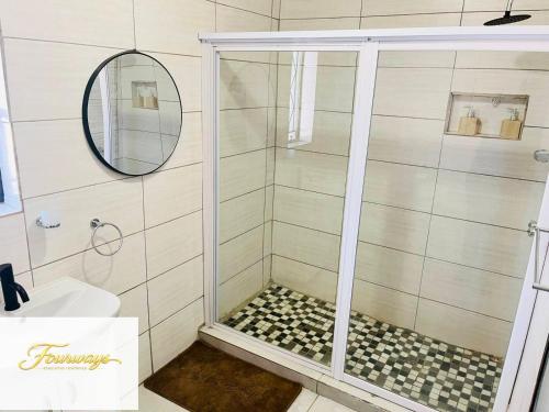 a bathroom with a shower with a glass door at Fourways Executive Residence in Four Ways