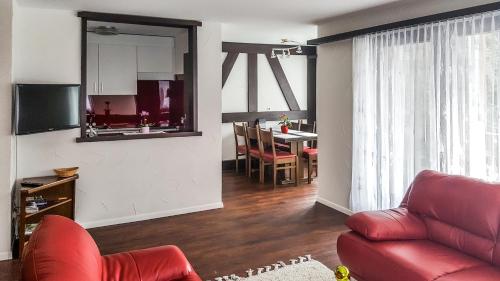 a living room with a red couch and a table at Apart-hotel Channa in Saas-Almagell