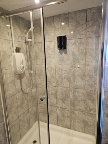a shower with a glass door in a bathroom at Waterfront Hotel in Deal
