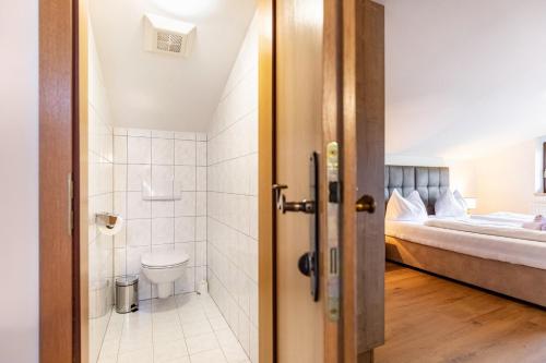 a bathroom with a toilet and a bedroom with a bed at Apartment - Ferienwohnung Elisabeth in Radstadt