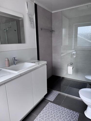 a white bathroom with a sink and a toilet at Ferienwohnung Martin in Neuhausen ob Eck