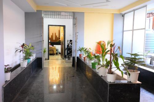 a hallway with potted plants in a room at Hotel O Westin Regency in Monber