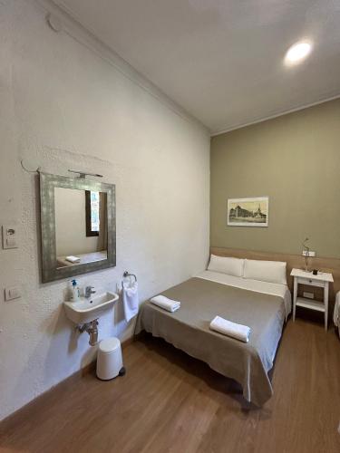 a bedroom with a bed and a sink in it at Hostal Delfos in Barcelona
