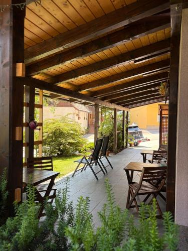 a patio with tables and chairs under a wooden pergola at Rooms Ravnik in Bled
