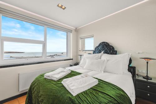 a bedroom with a large bed with towels on it at Diamond Suites by Reykjavik Keflavik Airport in Keflavík