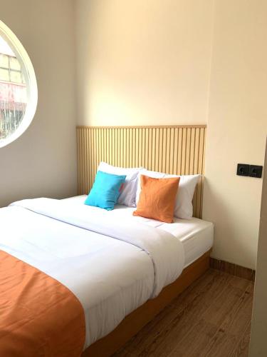 a bed with three pillows on it in a room at Sera INN Cikarang in Jatirarangan
