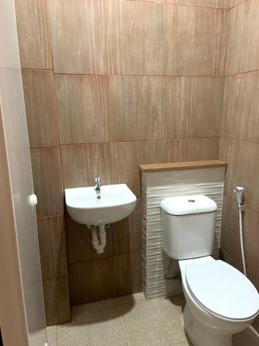 a bathroom with a toilet and a sink at Sera INN Cikarang in Jatirarangan