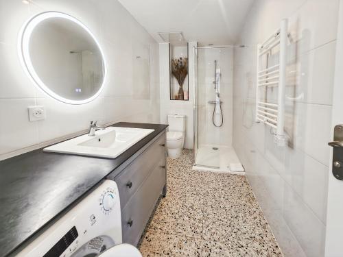 a bathroom with a sink and a toilet and a mirror at L'atelier Lena, Calme, Confort, 10 min Disneyland in Montry
