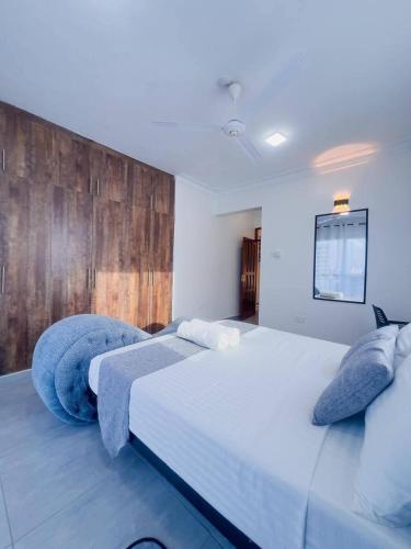 a bedroom with a large white bed with blue pillows at The palace001 in Mombasa