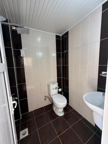 a small bathroom with a toilet and a sink at Holiday Hotel in Erdemli
