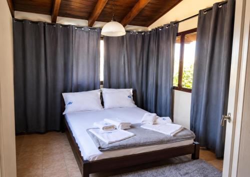 a bedroom with a bed with blue drapes at Panorea house in Polydrossos