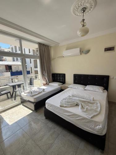 a bedroom with two beds and a large window at Holiday Hotel in Erdemli