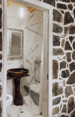 a bathroom with a sink and a stone wall at VEIS Country House in Kamenicë