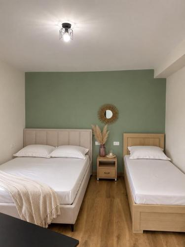 a bedroom with two beds and a mirror on the wall at Melody's Room in Borsh