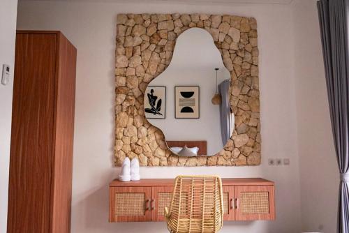 a bathroom with a mirror and a wooden cabinet at Selena Home Tropical Villa Jimbaran in Jimbaran