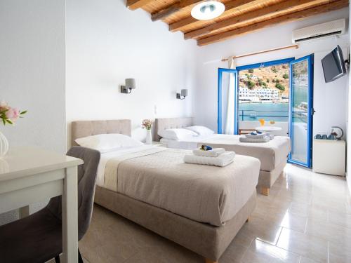 a hotel room with two beds and a balcony at Sifis in Loutro