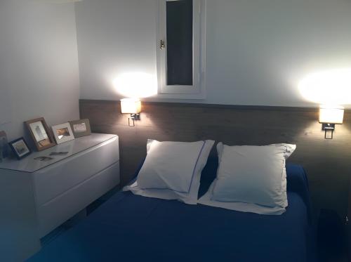 a bedroom with two lamps and a bed with two pillows at Appart avec terrasse proche mer in Macinaggio