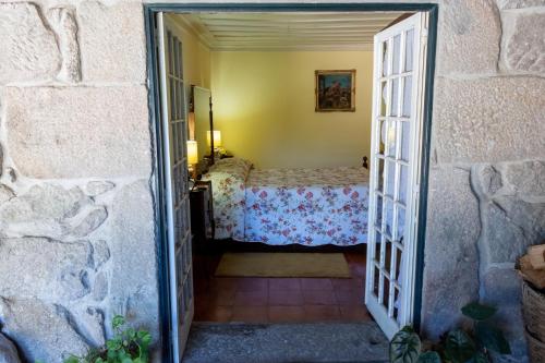 a door leading into a bedroom with a bed at Quinta de S.Vicente in Geraz do Minho