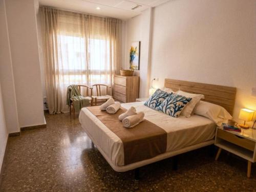 a bedroom with a large bed with towels on it at Casa Centro 48 by Eden Mar - Ideal para estancias temporales in Guardamar del Segura