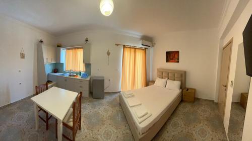 a bedroom with a bed and a table in it at Levend Apartments in Ksamil