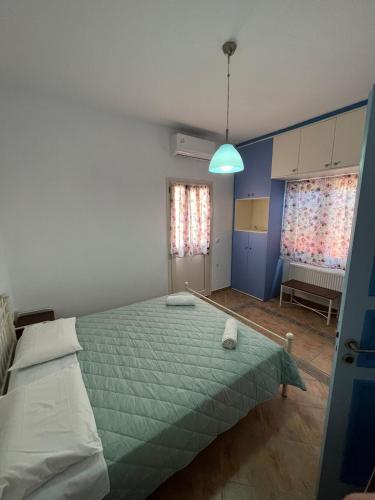 a bedroom with a large bed with a green comforter at Choios' House in Kondoliánika
