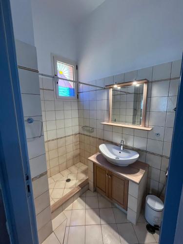 a bathroom with a sink and a toilet and a mirror at Choios' House in Kondoliánika