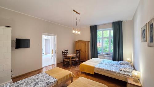 a bedroom with two beds and a window at ENKLAWA Apartamenty in Przemyśl