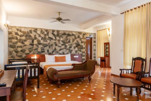 a hotel room with a bed and a chair at By The Bay Kovalam in Trivandrum