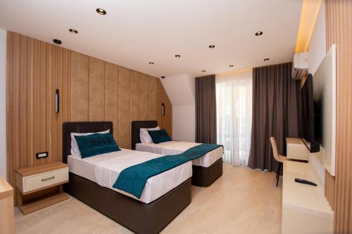 a hotel room with two beds and a television at Premium Apartments Zevs in Budva