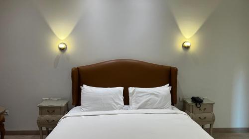 a bedroom with a bed with white sheets and lights at Riverside Hotel in Cairo
