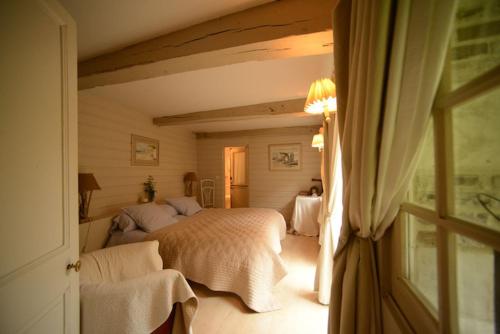 a bedroom with a large bed and a window at Le Clôs Ste Anne in Eu