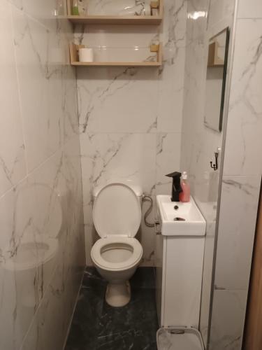 a white bathroom with a toilet and a sink at u Oli Dawid Spaczyński in Mrzeżyno