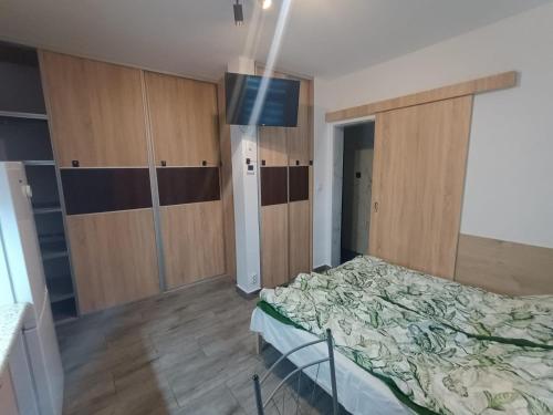 a bedroom with a bed and wooden cabinets at u Oli Dawid Spaczyński in Mrzeżyno