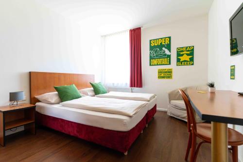 a bedroom with a bed and a desk and a table at SLEEEP Hotel Sattledt in Sattledt