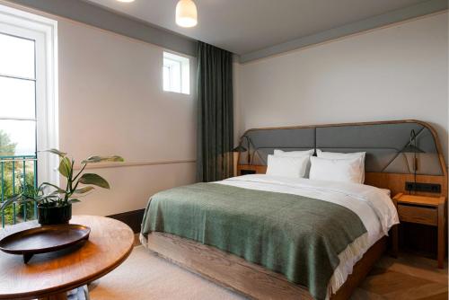 a hotel room with a bed and a table at CORI Hornbæk Hotel in Hornbæk