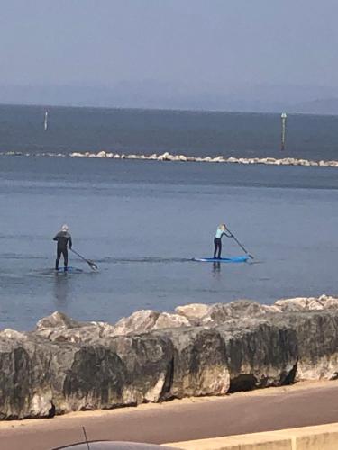 two people in the water with paddles in the ocean at Sunsets, Sandylands Prom Morecambe in Morecambe
