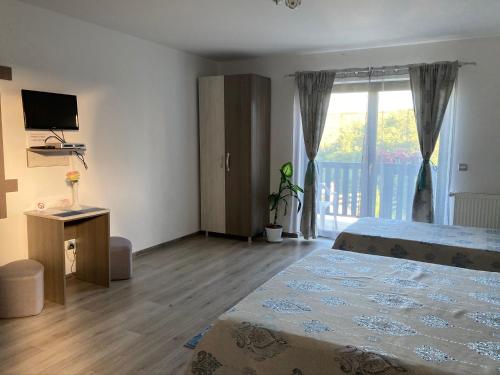 a bedroom with a bed and a sliding glass door at Casa Poarta Paradisului in Moldoveneşti