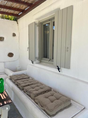 a window seat on the side of a house at Paros Poolside Cozy Nests - Summer & Salty Getaways in Kalami