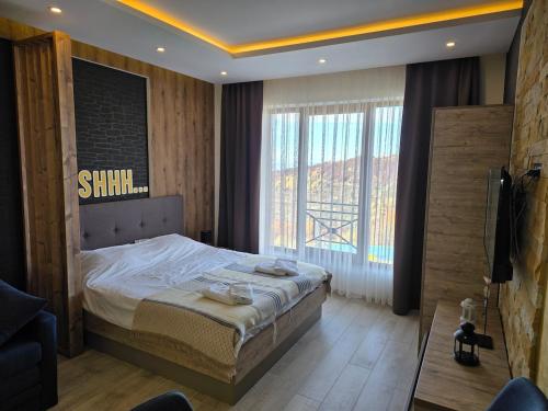 a bedroom with a bed and a large window at Sunset S12 Milmari in Raška