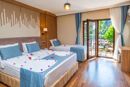 two beds in a room with a balcony at Caria Special Class in Dalyan