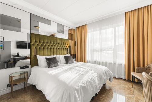 a bedroom with a large white bed and a chair at Hotel Keflavik by Reykjavik Keflavik Airport in Keflavík